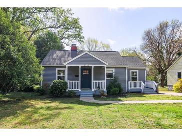 Charming single-story home featuring a cozy front porch, well-maintained lawn, and mature trees at 2741 Cowles Rd, Charlotte, NC 28208