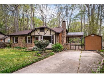 Charming brick home with a well-manicured lawn, covered car-port, and brick chimney at 313 E Church St, Stanley, NC 28164