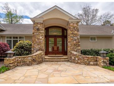 Grand front entrance featuring a custom wood door, stone accents, and elegant landscaping at 345 Porters Glen None, New London, NC 28127