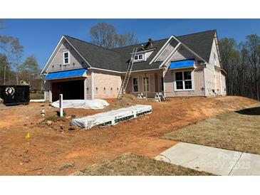 New home exterior under construction with a dark roof, ladder, and blue sky at 387 Lucky Nw Dr # 18, Concord, NC 28027