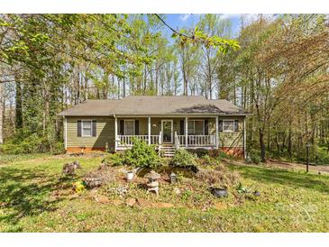 Charming ranch-style home featuring a cozy front porch and beautiful landscaping with a tranquil pond at 4896 Birch Cir, Hickory, NC 28602