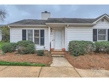 Charming single-story home with a white exterior, complemented by manicured landscaping and a welcoming front door at 5913 Crape Myrtle Ln, Charlotte, NC 28216