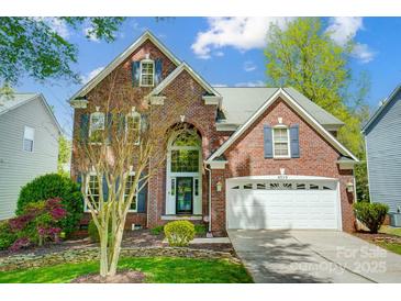 Charming two-story brick home featuring an attached two-car garage and manicured front lawn at 6519 Summertree Ln, Charlotte, NC 28270