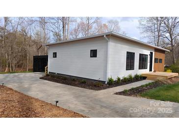 Modern home featuring white horizontal siding, black trim, and a concrete driveway at 6548 Emerald Isle Dr, Sherrills Ford, NC 28673