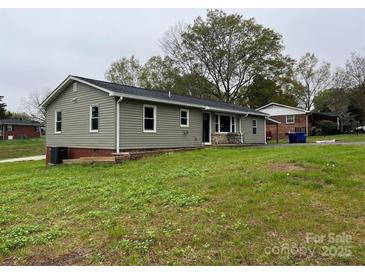 View of the home's exterior, featuring vinyl siding and a well-maintained lawn at 8124 Wood St, Mount Pleasant, NC 28124