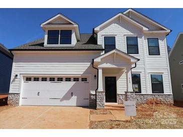 Charming two-story home with white siding, stone accents, a garage, and a well-manicured yard, perfect for curb appeal at 919 Mankey Dr, Huntersville, NC 28078
