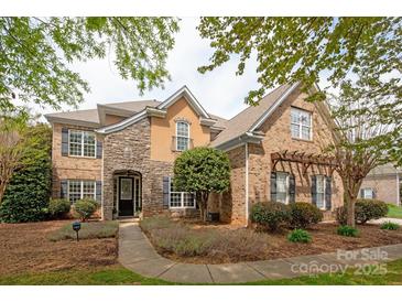 Charming two-story home with a combination of brick, stone, and stucco facade, and well-manicured landscaping at 11308 Wheat Ridge Rd, Charlotte, NC 28277