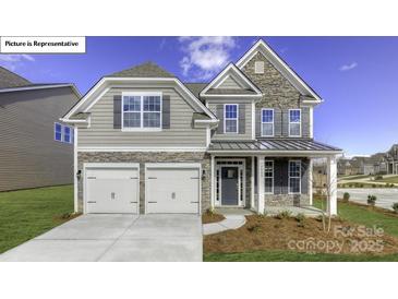 Charming two-story home with stone accents, a two-car garage, and professionally landscaped yard at 122 Fordingbridge Ln, Mooresville, NC 28115