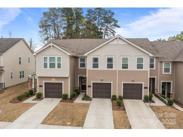 Charming townhome showcasing a well-manicured lawn, attached garages, and a welcoming two-story facade at 16038 Red Buckeye Ln, Huntersville, NC 28078