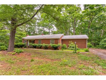 Charming brick ranch-style home nestled among mature trees with a well-maintained front yard at 235 John Rainey Rd, Salisbury, NC 28147