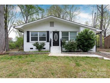 Charming single-story home featuring a white brick exterior and a well-manicured front yard at 2408 Dora Dr, Charlotte, NC 28215