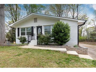 Charming home featuring a brick exterior and landscaped front yard with lush greenery and inviting curb appeal at 2408 Dora Dr, Charlotte, NC 28215