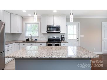 Modern kitchen with granite countertops, stainless steel appliances, and white cabinetry at 2408 Dora Dr, Charlotte, NC 28215
