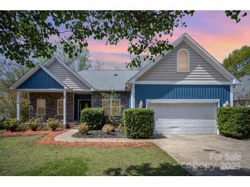 Charming home featuring stone accents, blue siding, a well-manicured lawn and an attached two-car garage at 3846 Bent Creek Sw Dr # 58, Concord, NC 28027