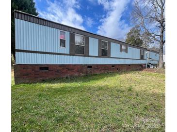 Charming single-Gathering home with blue siding, brick foundation, and a well-maintained lawn at 1085 Percy Ln, Rockwell, NC 28138