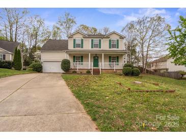 Charming two-story home with a welcoming front porch and well-maintained lawn and long concrete driveway at 11415 Serenity Way, Charlotte, NC 28269