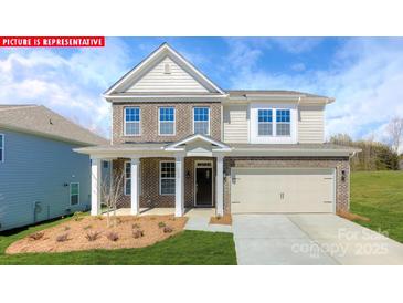 Charming two-story home with brick and siding, features a manicured lawn, and an attached two-car garage at 118 Fordingbridge Ln, Mooresville, NC 28115