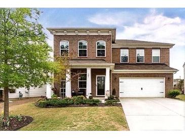 Charming brick two-story home with well-manicured lawn and a two-car garage on a sunny day at 121 Little Kennerly Dr, Mooresville, NC 28115