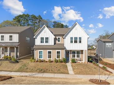 Charming two-story home with white and tan siding, complemented by a well-manicured front yard and sidewalk at 12110 Anne Blount Aly, Huntersville, NC 28078