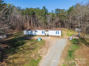 Charming single-Gathering home with a lovely yard surrounded by lush trees and the convenience of outside storage at 1375 Percy Ln, Rockwell, NC 28138