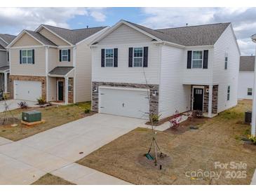 Charming two-story home with white siding, stone accents, a two-car garage, and a well-maintained lawn at 14217 Wilson Mac Ln, Charlotte, NC 28278