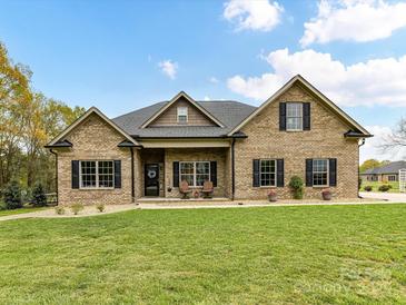 Charming brick home with a manicured lawn, covered porch, and classic black shutters at 3012 Ocean Dr, Monroe, NC 28110