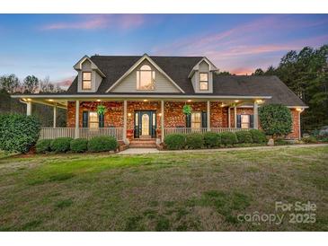 Charming brick home with a welcoming front porch and beautifully landscaped front yard at 361 Nance Rd, Stanfield, NC 28163