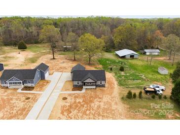 Expansive aerial view of a new home build, showcasing the surrounding wooded acreage and outbuildings at 3957 Miller Rd, Salisbury, NC 28147