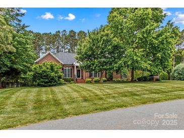 Charming brick home featuring a lush, manicured front lawn and mature trees offering great curb appeal at 4159 Isle Of Pines Dr, Denver, NC 28037