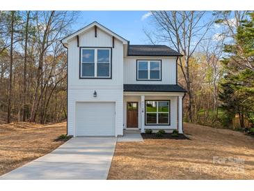 Charming two-story white home featuring a garage and a well-manicured lawn at 4219 Brownwood Nw Ln, Concord, NC 28027