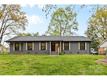 Charming single-story home featuring a well-manicured lawn, stylish shutters, and a welcoming front entrance at 7009 Wrentree Dr, Charlotte, NC 28210