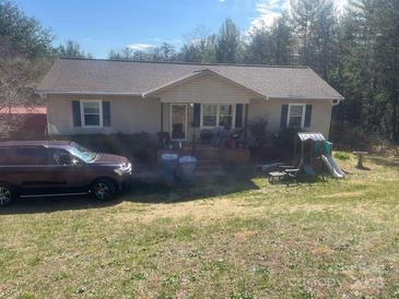 A ranch style home with light colored siding and a front yard with green grass, trees and a playground at 7122 Pyramid Rd, Hickory, NC 28602