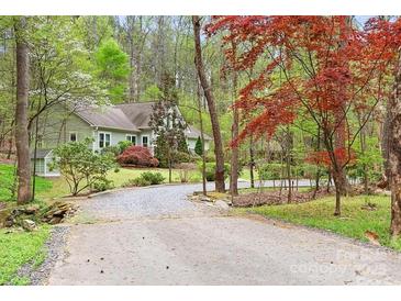 Charming home nestled among trees, featuring a gravel driveway and lush landscaping for a serene and private setting at 113 Duval Ct, Mooresville, NC 28117