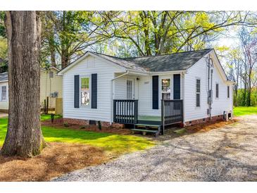 Charming home featuring a front porch, crisp white siding, and black shutters in a serene, wooded setting at 1157 Cedar Grove Ln, Rock Hill, SC 29732