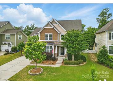Charming two-story home with a manicured lawn, mature trees, and inviting front entrance at 1224 Screech Owl Rd, Waxhaw, NC 28173