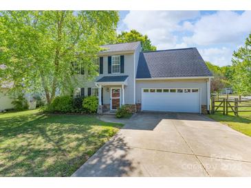 Charming two-story home features a spacious driveway, an attached garage, and beautifully landscaped front yard at 12604 Cardinal Point Rd, Charlotte, NC 28269
