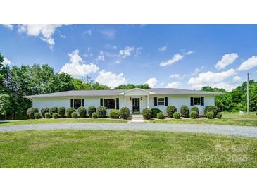 Charming ranch-style home featuring manicured lawn and mature landscaping on a sunny day at 12842 Plaza Road Ext, Charlotte, NC 28215