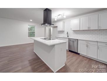 A modern kitchen features an island, stainless steel appliances, and crisp white cabinetry at 129 Wilson St, Chester, SC 29706