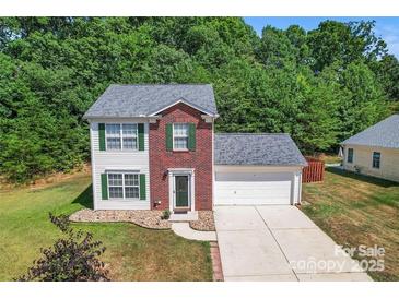 Charming two-story home with brick accents, green shutters, attached garage, and well-maintained landscaping at 140 Camforth Dr, Mooresville, NC 28117