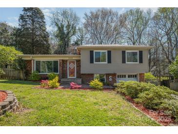 Split-level home with a brick and siding exterior, front lawn and small garden at 1421 Sherwood Dr, Kannapolis, NC 28081
