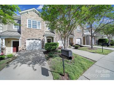 A row of townhomes showcasing stone accents, garages, and well-maintained landscaping at 14256 Drake Watch Ln, Charlotte, NC 28262