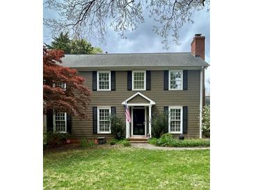 Charming two-story home with dark shutters, beautiful lawn, chimney, and manicured landscaping at 1650 Maryland Ave, Charlotte, NC 28209
