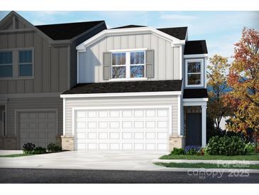 Charming two-story home with white garage door and front yard landscaping at 1713 Braemar Village Dr, Monroe, NC 28110