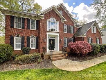 Beautiful brick home with a manicured lawn, lush landscaping and black window shutters create curb appeal at 6114 Abergele Ln, Matthews, NC 28104