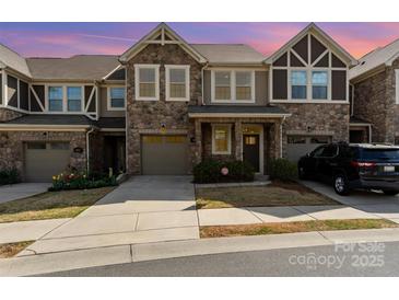 Charming townhome featuring stone accents, a one-car garage, and well-maintained landscaping at 1030 Archibald Ave, Fort Mill, SC 29708