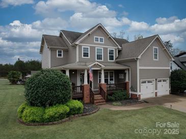 Charming two-story home featuring a welcoming front porch, manicured lawn, and a two-car garage at 15211 Windward Ln, Lancaster, SC 29720