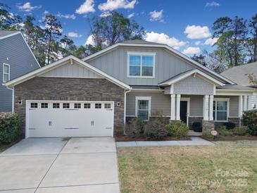 Charming two-story home with stone accents, a two-car garage, and a well-maintained front yard at 1718 Still River Way, Fort Mill, SC 29708