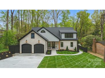 Charming two-story home with white brick, black accents, two-car garage, and manicured lawn at 3038 Northampton Dr, Charlotte, NC 28210