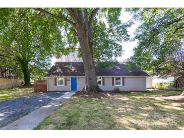 Charming ranch home featuring a bright blue front door and a well-manicured yard with mature trees at 307 S Ransom St, Gastonia, NC 28052