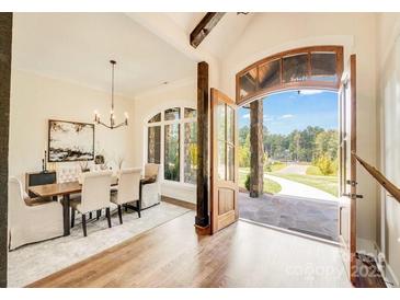 Open dining room with hardwood floors, modern lighting, and a view to the outside at 6422 Chimney Bluff Rd, Lancaster, SC 29720